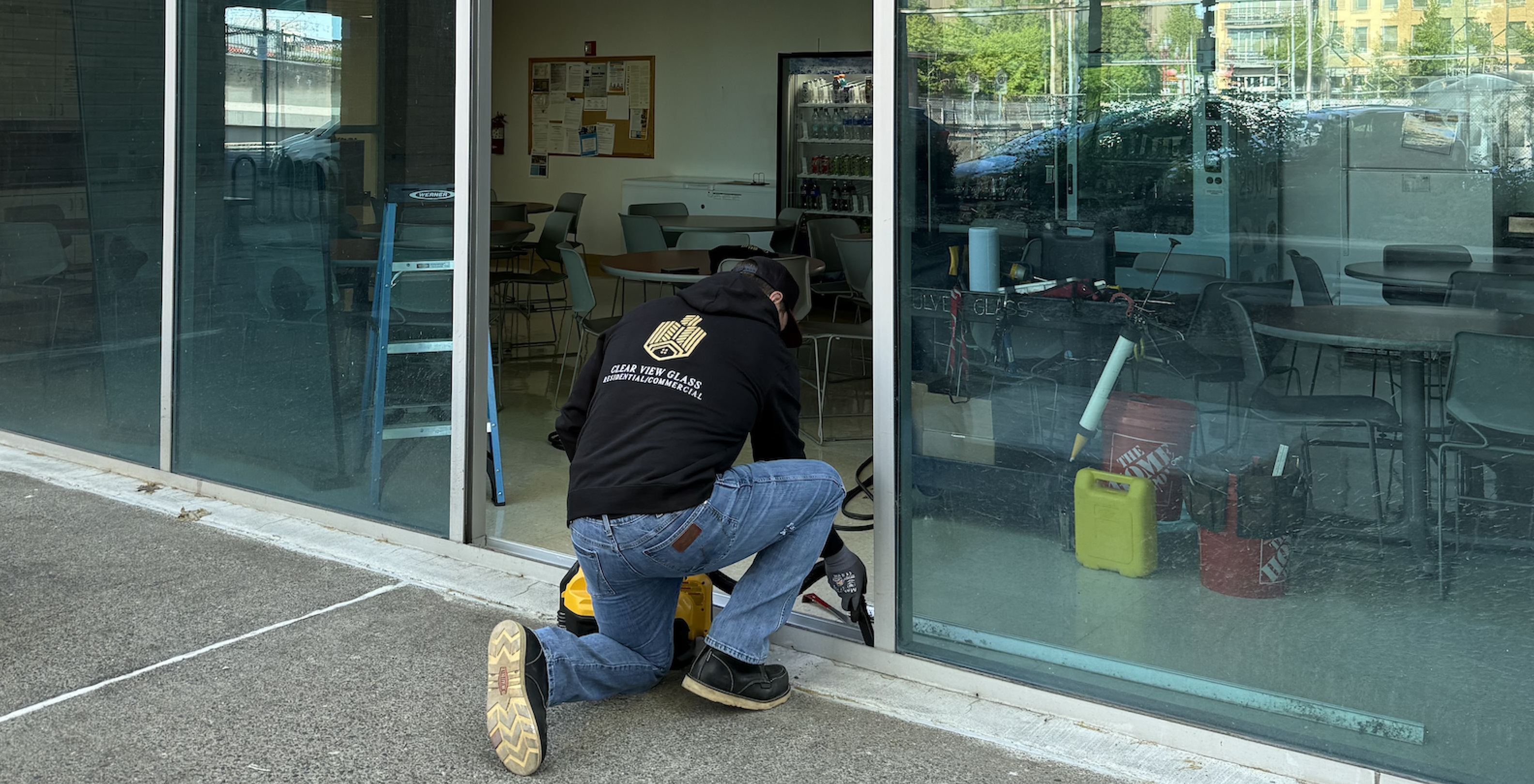 Man working on installing glass panels on commercial building