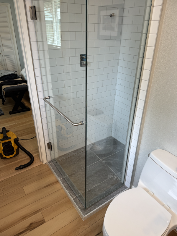 Corner glass pieces forming walk in shower in bathroom